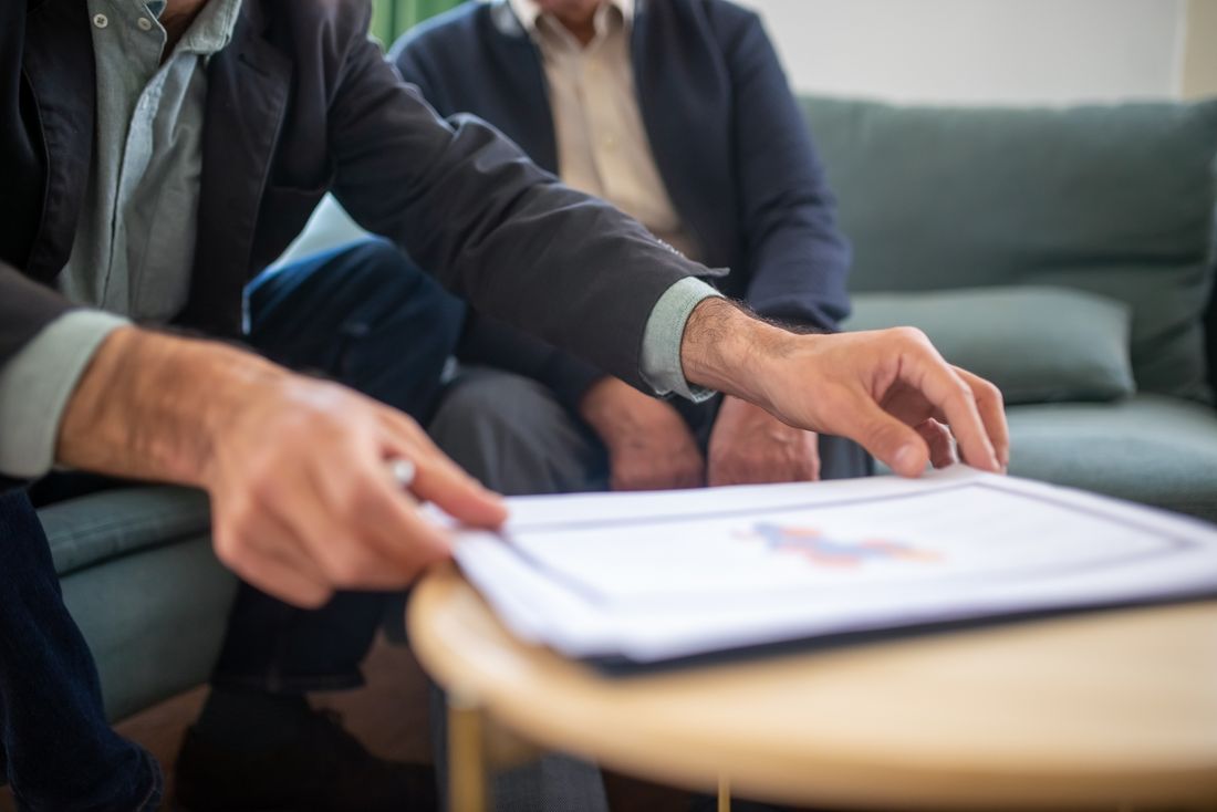 Due persone si confrontano su documenti durante una consulenza
